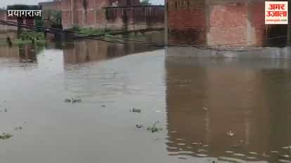 Floodwaters reach Lane No. 21 of Rajapur; residents begin moving belongings out of their homes.